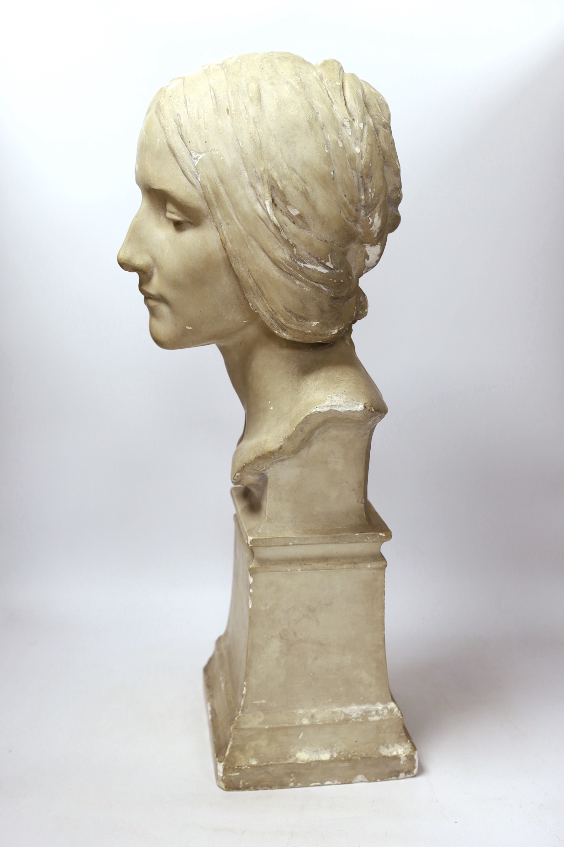 A plaster bust of a woman’s head on a square pedestal, 58cm